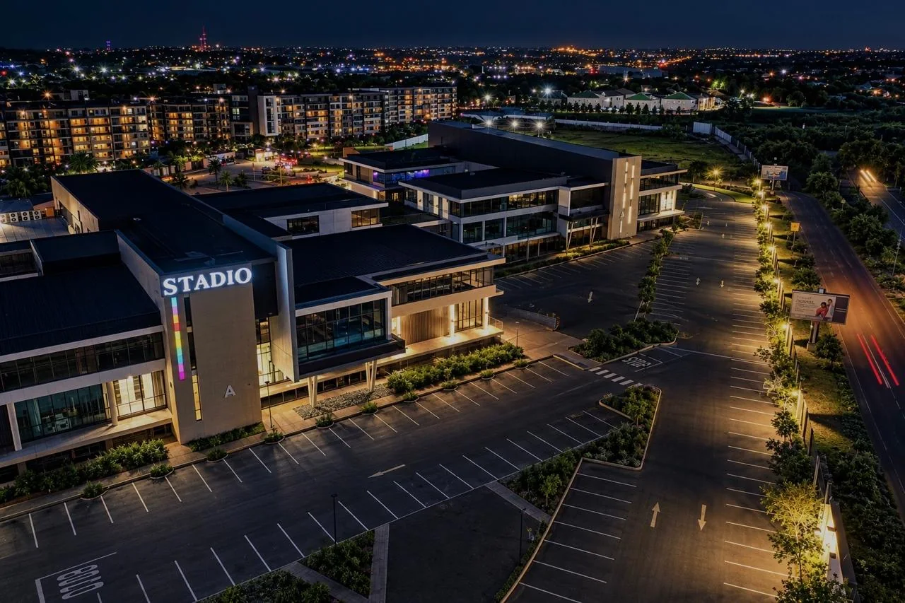 Aerial night view of the illuminated STADIO campus sign